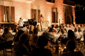 Schon zum 10. Mal eröffnet im März dieses Jahres das einzigartige Castell Son Claret seine Pforten. Das landschaftliche Anwesen, inmitten von traumhafter Naturkulisse und einem paradiesischen Garten, bietet anspruchsvollen Gästen eine Oase der Ruhe. Das Castell Son Claret, Mitglied der Leading Hotels of the World, liegt am Fuße des Tramuntana-Gebirges in Calvià und ist mit seinen liebevoll und originalgetreu restaurierten 41 Zimmer und Suiten im historischen Schloss ein Unikat. Die Eigentümer, Christine und Klaus-Michael Kühne, haben Wert darauf gelegt, nicht nur die Räume und das Schloss respektvoll umzugestalten, sondern auch die weitläufigen Gärten möglichst zu erhalten. Für den kulinarischen Genuss sorgt Küchenchef José Forteza in dem Restaurant Olivera. Anlässlich dieses Jubiläums sind einige besondere Veranstaltungen im Laufe des Jahres geplant. Ein Artist Workshop für Kunstbegeisterte mit der Malerin Carolina Amigo lässt einen Einblick hinter den Kulissen auf die Kunstwerke von Son Claret. Ebenso kommen Musikbegeisterte auf ihre Kosten, in dem sie einen Nachmittag lang zusammen mit dem Chefdirigenten des Orquestra Simfònica de les Illes Baleares (OSIB), Pablo Mielgo, über seine SaludArte Foundation erfahren und welches künstlerisches und soziales Engagement durch die Musik anstrebt ist. Ein ganz besonderes Highlight auch in diesem Jahr sind die Sommerkonzerte Castell Classics 2023 mit einer herausragenden Besetzung. An nur drei Abenden im Juni, Juli und August veranstaltet das 5-Sterne Luxushotel seine Castell Classics mit Aufführungen von einigen der renommiertesten Opernhäuser Europas, den Salzburger Opernfestspielen, dem Opernhaus Leipzig und dem Teatro de Maggio Fiorentino. Das Classic Event startet am 15. Juni mit dem Young Singer Project der Salzburger Festspiele.. Am 27. Juli sind die internationalen Stars Olena Tokar und Dmytro Choni zu Gast und am 10. August bieten Sängerinnen und Sänger der Akademie Teatro del Maggio Musicale Fiorentino einen Abend voller italienischer Arien 2